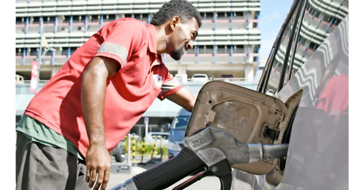 A gas station attendent provides fuel services to one of many vehicle owners who queued up on March 31, 2026, prior to the new price increase announcement by the FCCC.