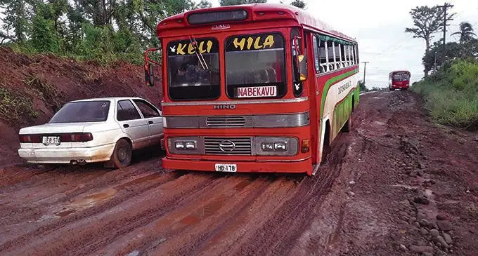 A Dalip Chand and Son Buses Limited and a vehicle bogged on a road in the North.  Photo: Dalip Chand and Son Buses Limited