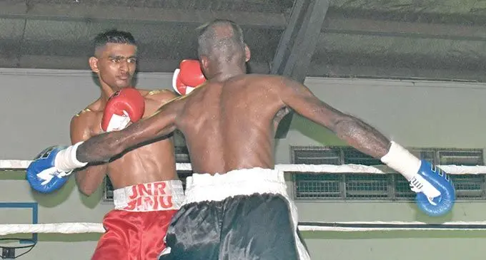 From left; Junior Binnu Singh lands a jab on Ritesh Goundar’s (back to the camera) face during their title fight in Nadi on June 11, 2022. Photo: Waisea Nasokia