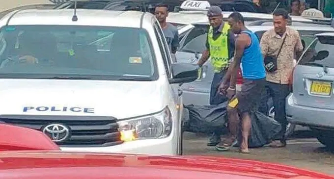 Police and helpers carry the body bag containing the dead man.