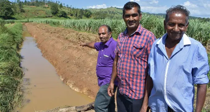 Ministry of Waterways senior agriculture officer Northern Gyan Chandra pointing at the drainage work as he stood with his Labaasa drainage board field man Arvin Chand and sugarcane farmer Ram Sanai (right) at Coqeloa in Labasa on February 13, 2018.  Photo: Shratika Naidu