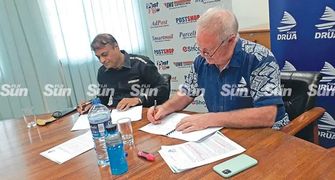 Post Fiji chief executive officer Anirudha Bansod (left) and Fijian Drua chief executive officer Brian Thorburn signing ticket sales agreement at the Post Fiji boardroom in Suva on March 18, 2022. Photo: Sereana Salalo.