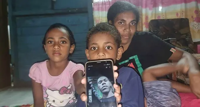 Litea Marama with her children holding a photo of the late Naibuka Serulaqeti at Vusuya, Nausori.