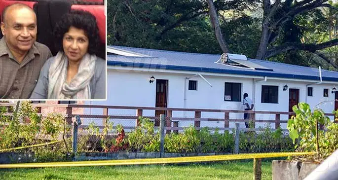 A Police officer looks through a window at the house in Korokoro Road in Sigatoka on February 3, 2021, where the bodies of the elderly couple were found. Photo: Nicolette Chambers. Inset: Deceased couple Sesha Reddy and wife Mirdu Chandra