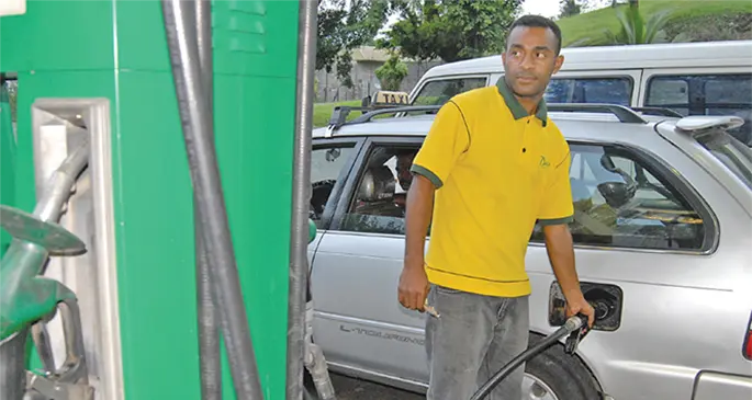 An attendant filling fuel to a taxi.