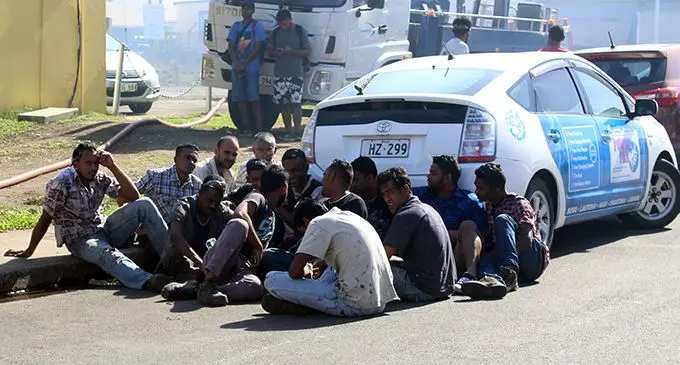 Workers from P.A. Lal Holdings LTD sit beside the roadside after their workplace in Walu Bay caught fire on July 22,2019.  Photo: Simione Haravanua