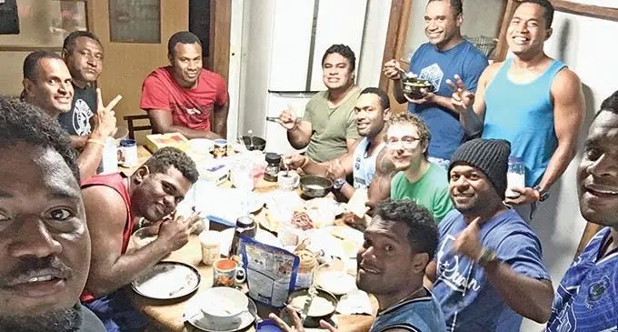 Fijians who are part of the Japan International Sports Partnership enjoy their meal in the midst of the typhoon on Saturday night in Yokohama, Japan.