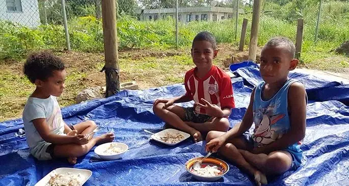 Children of Korociri in Nadi tuck into their meals.