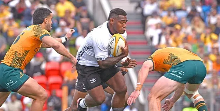 Flying Fijians Josua Tuisova leads the charge against Australia’s Tom Wright (left) and Len Ikitau (right) during the Test match between Australia and Fiji at McDonald Jones Stadium in Newcastle on July 6, 2025. Photo: SAEED KHAN / AFP