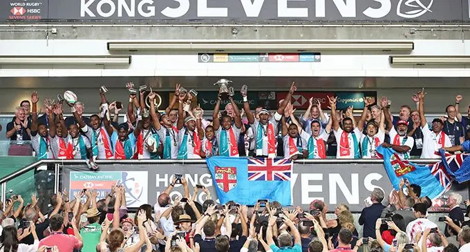 In happier times,,, Tomasi Cama Snr (right, with red cap and Fiji flag) celebrates with Fiji Airways Fijian 7s players and officials after winning the Hong Kong 7s tournament last year for a record fifth-year-in a- row. Photo: World Rugby