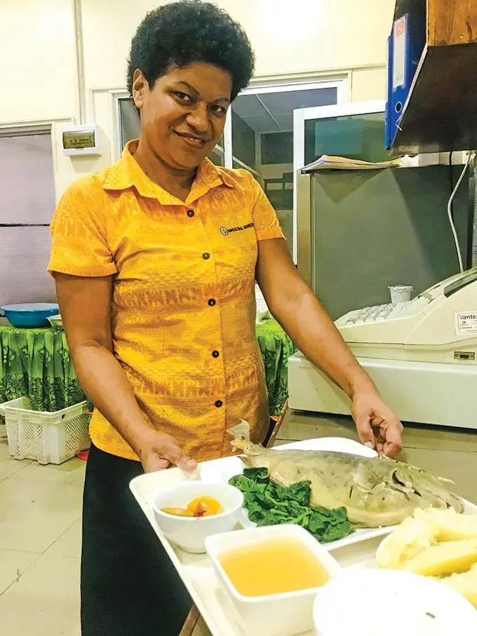 Vasemaca Rokonai displays a serve of boiled fish that’s prepared at Sautu restaurant  Photo: Frederica Elbourne 