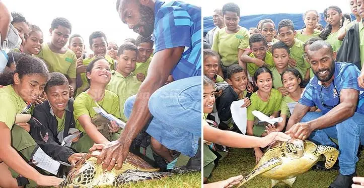 Ministry of Fisheries staff Timoci Nakaruru shows a green turtle to students during the World Oceans Day at Albert Park on June 8, 2023. Photo: Ronald kumar