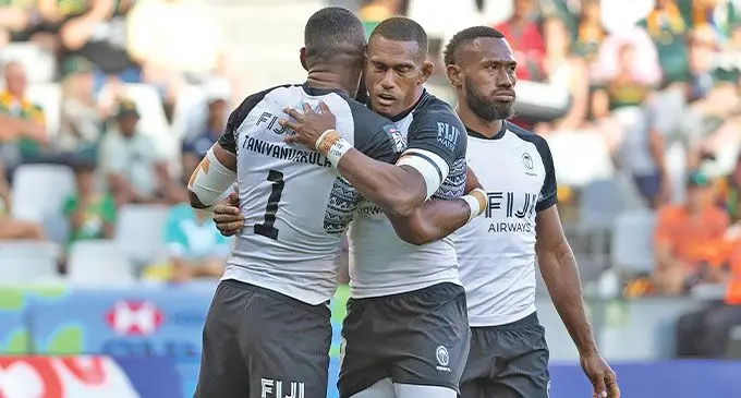 Fiji men's rugby sevens forward Kavekini Tanivanuakula (back to the camera) is congratulated by Suliano Volivolituevei and Ioane Teba after they finished third at the OHL Stadium in Cape Town, South Africa, on December 7, 2024. Photo: World Rugby
