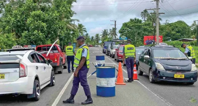 Police officers monitor motorists at a chekpoint along Princes Rd, Suva. Photo: Police Media Cell