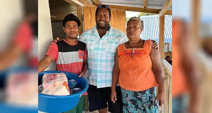 Captain Steven Tawake (middle), delivering some essentials to the baby’s father, Bruce, and a relative.