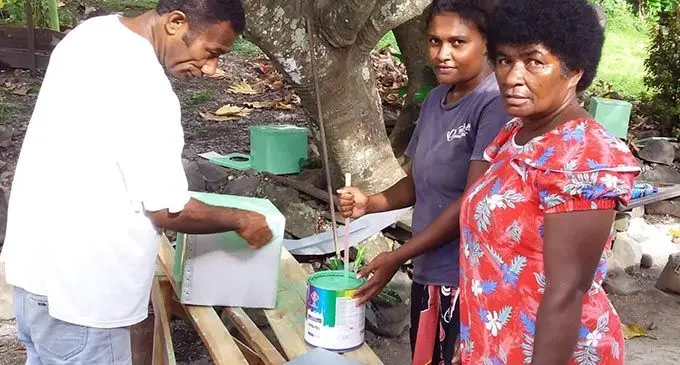 Participants painting the rocket stove during the workshop. Photo: Laisa Lui