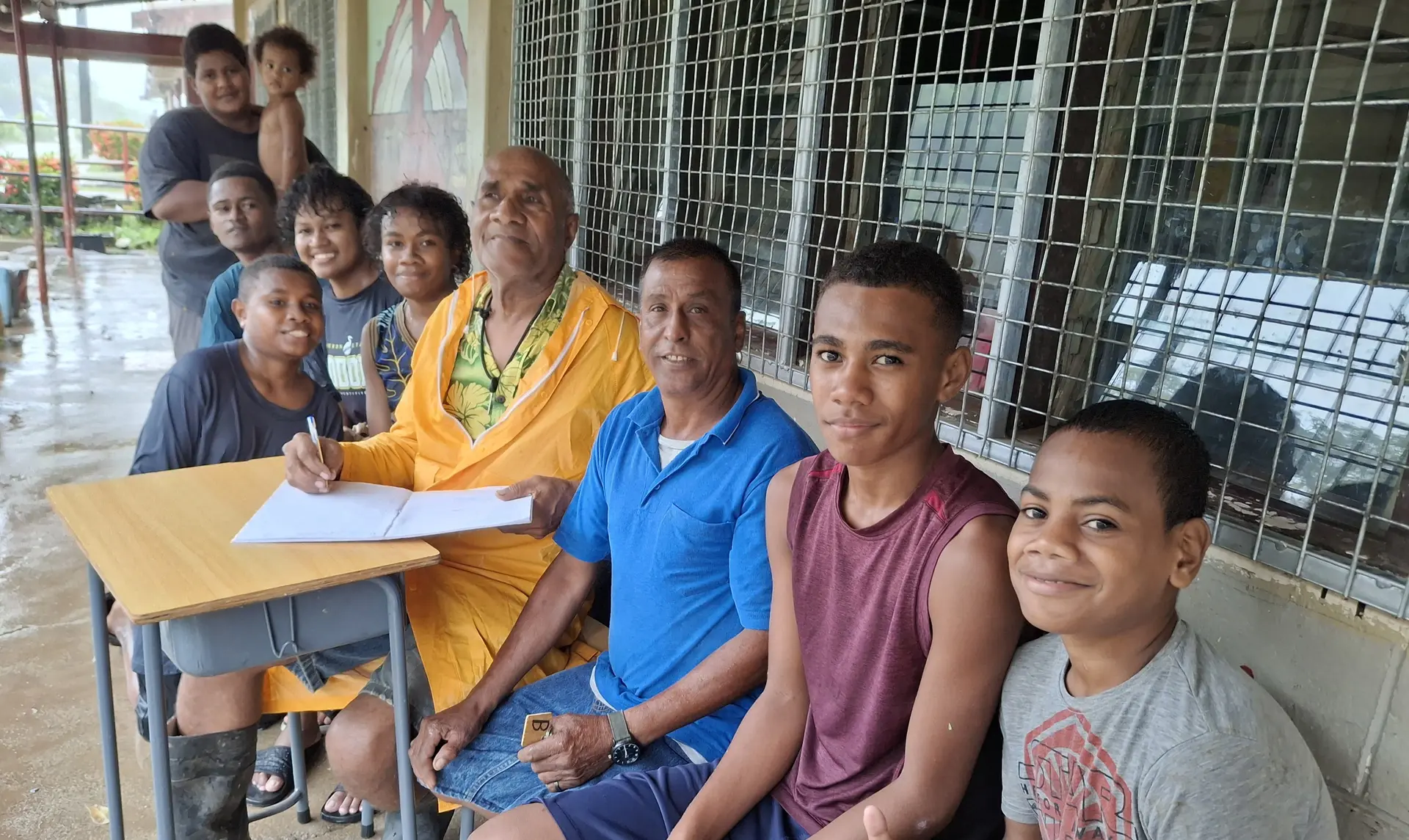 Veveni Waqa (holding a book and a pen) with other evacuees at the evacuation center.