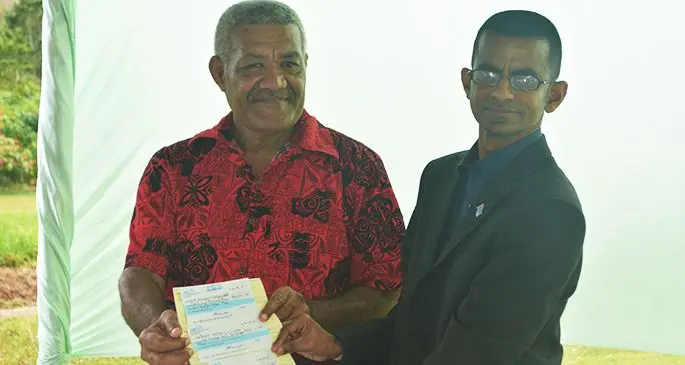 Fiji Hardwood Corporation Limited general manager Shakeel Maharaj handing over the cheques to Dreketi Mahogany Company Limited chairman Kitione Yacadra on September 16, 2019.