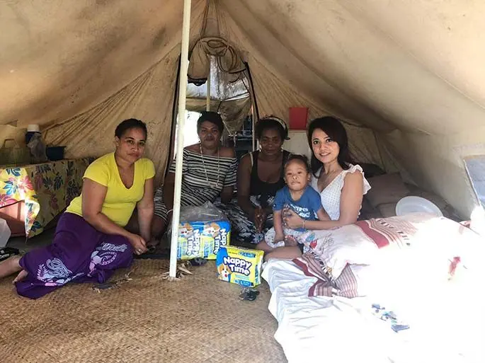 Piniaua Vukicanatani (third from left) and her son with the team from Make a Difference Fiji inside her makeshift tent in Culunuku Village, Serua.