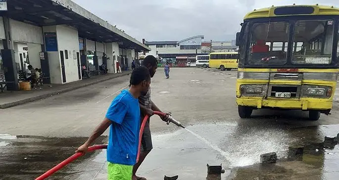 Nausori Town Council workers cleaning the bus stand.