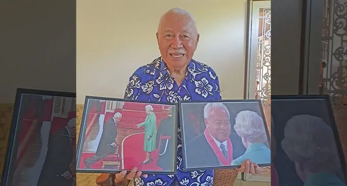 Sir James Ah Koy at his residence in Namadi, holding photos of him being knighted and meeting the late Queen Elizabeth II. Photo: Viliame Tawanakoro