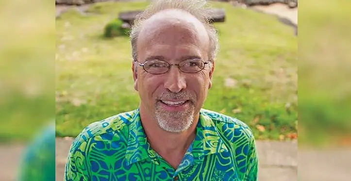Coral reef ecologist Victor Bonito holding onto a piece of coral.