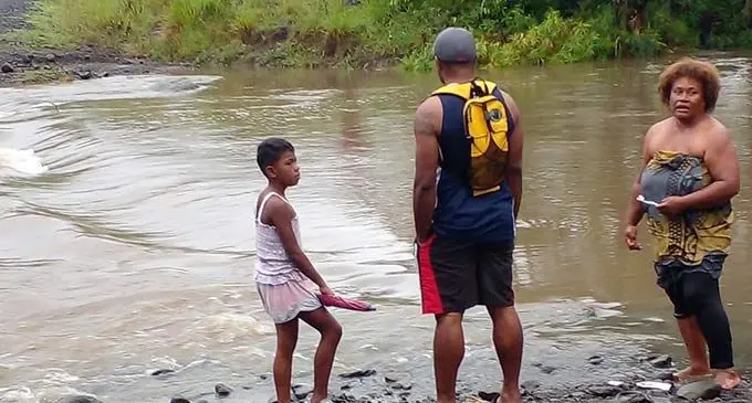 Parents who helped their children cross the flooded rivers of Vatukacevaceva in Rakiraki on December 13, 2022. Photo: Nicolette Chambers