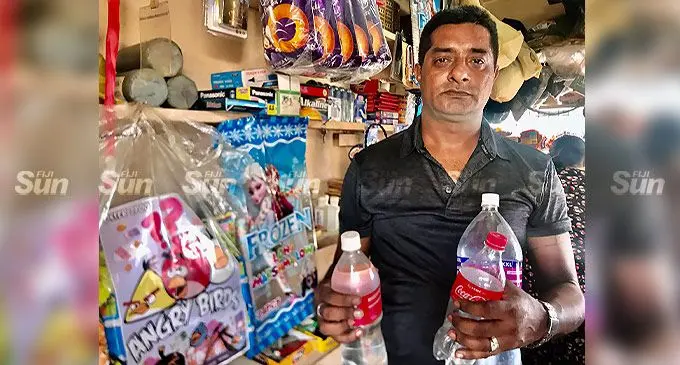 Suva Kiosk operator Avinash Ram with bottles of water he has to fill up because there was no water supply into the tap inside his kiosk. Photo: Inoke Rabonu