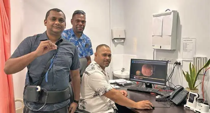 Patient (front) with Clinical Director Dr. Sanson Fousaga (sitting) and PSH Research and Development Team Head Solomone Suguta. Photo: Pacific Specialists Healthcare