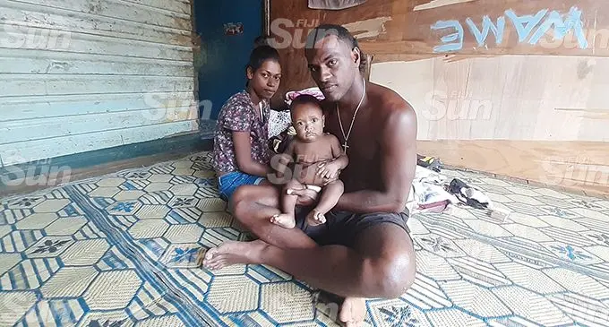 Waisea Raikadroka (right) holds his nine-month old son Bolau at their home in Kalekana yesterday. Losalini Lalaia, Talei’s mother sitting on the left. The couple believe their  missing daughter is alive.  Photo: Shalveen Chand