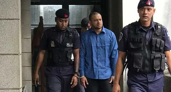 Jone Vakarisi handcuffed alongside a Police officer while being escorted to the Magistrates Court in Suva on October 5, 2022. Photo: Ashna Kumar 