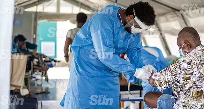 Emergency Department nurse Joshua Lewenilovo, on July 22, 2021, attends to one of the many COVID-19 patients accommodated in one of the tents that were set up outside the Colonial War Memorial Hospital. Photo: Leon Lord