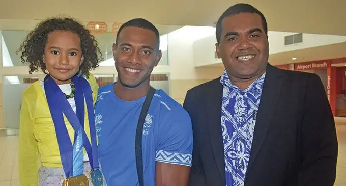 From left: Banuve Tabakaucoro carries his cousin Tiriani Banuve with Assistant Minister for Sports Alipate Nagata at Nadi International Aiport on July 21, 2019  Photo: Waisea Nasokia