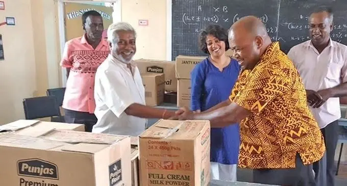 TISI Sangam secretary-general, Damend Gounder, (left) distributing stationery packs to the school management representative from Penang Sangam School in Ra.