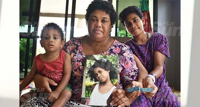 Iliseva Lewaqai with her two children. Vilimaina Vuniyayawa (right), and Nauru Vuniyayawa as she holds a photo of her late daughter Mereoni Lewasomo Vuniyayawa at Viseisei Village at Vuda, Lautoka. Photo: Mereleki Nai.