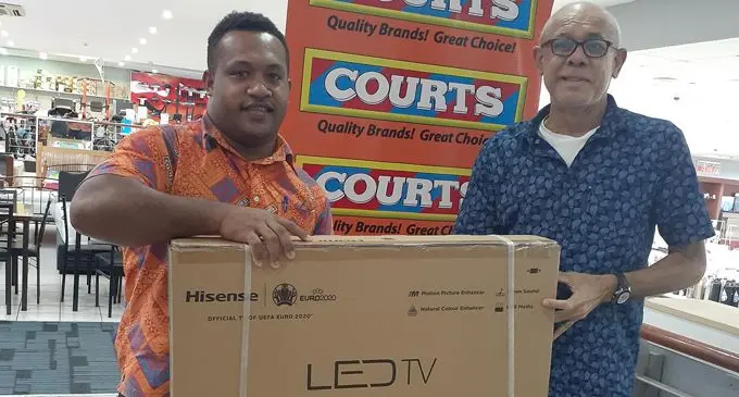 Winner Simon Hazelman with Courts Trainee Manager Vesi Lanyon at Courts Mega Samabula.