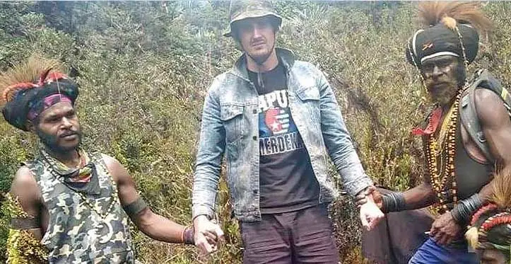 Papuan separatist rebels pose for a photo with Kiwi pilot Phillip Mark Mehrtens, who they took hostage. Photo: NZ Herald
