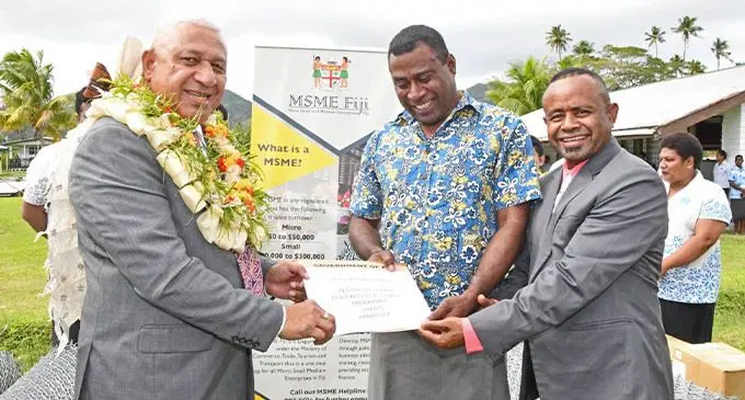 Prime Minister Voreqe Bainimarama hands over the Human Resources Development Programme assistance to Taniela Kama at  Tavuki Village in Kadavu. Photo: DEPTFO News