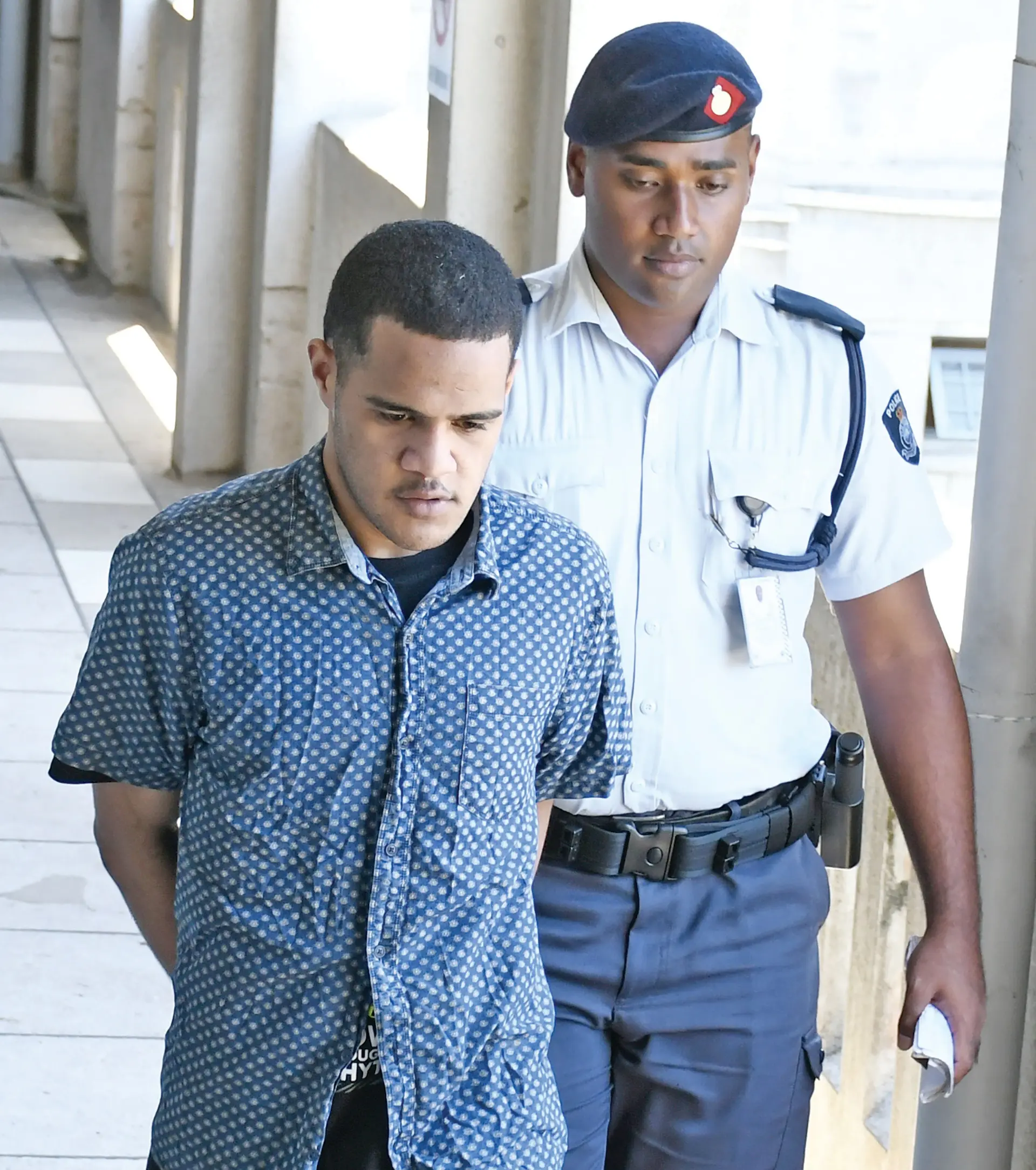 Timoci Matanikeke is escorted by a police officer to the High Court in Suva on December 18, 2025.