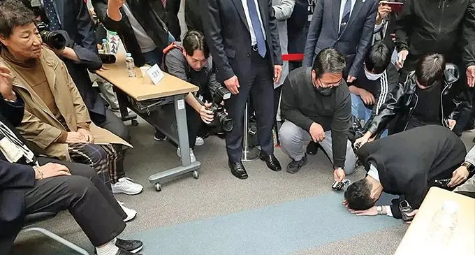 Chun Woo-won (R) bows to relatives of the victims. Photo: BBC News
