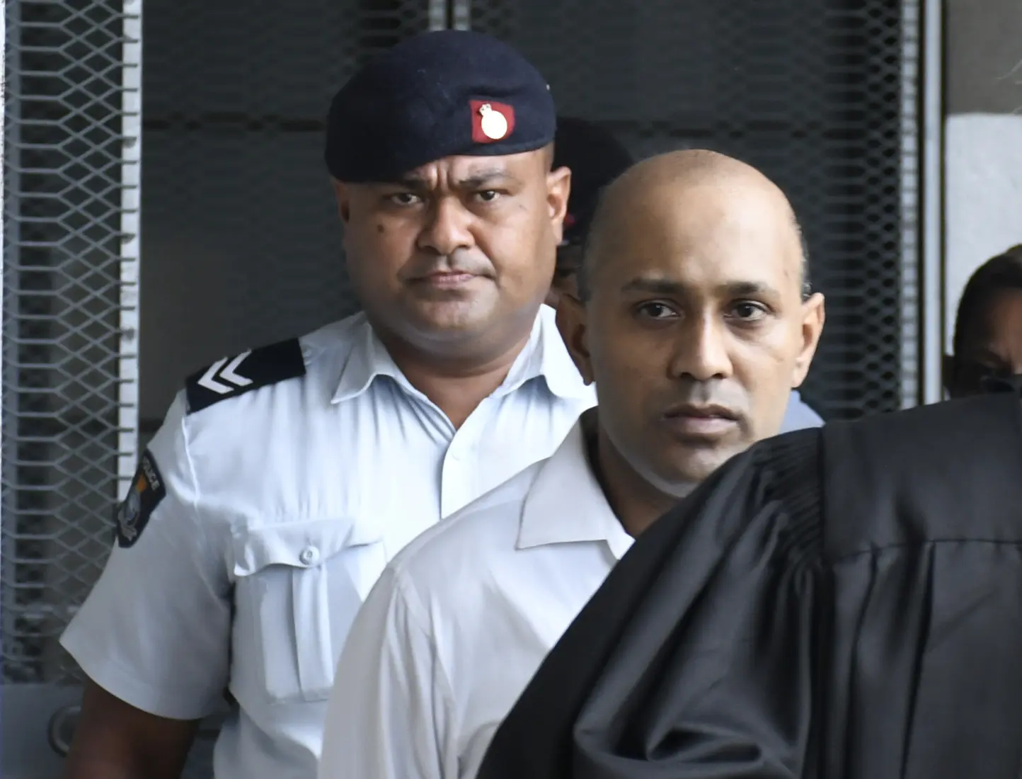 Jailed...Imraan Khan escorted by a police officer outside the High Court in Suva.