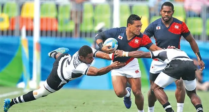 Japan 7s utility Lote Tuqiri against Fiji during the 2016 Olympic Games semi-final in Rio de Janeiro, Brazil. Making the tackle is forward Jasa Veremalua (left). Fiji won 20-7 to later claim the gold medal after beating Great Britain 43-7 in the final. Photo: Rugby World