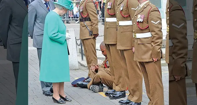 British Army Sergeant Rusiate Bolavucu (inset) sits down to perform the vakacobocobo as a sign of respect after greeting the Queen.