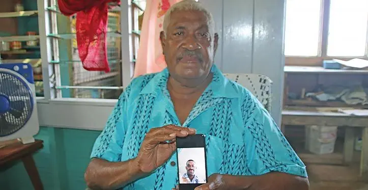 Meli Tauvoli, holding a picture of his nephew, Siona Ratulevu.