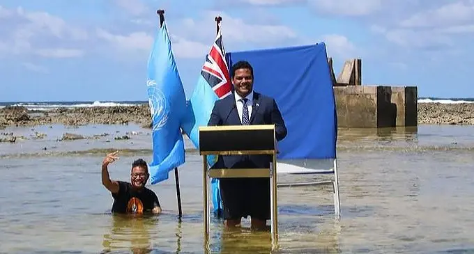 Tuvalu’s foreign minister, Simon Kofe, gives a COP26 statement while standing in the ocean in Funafuti. Photo: RNZ