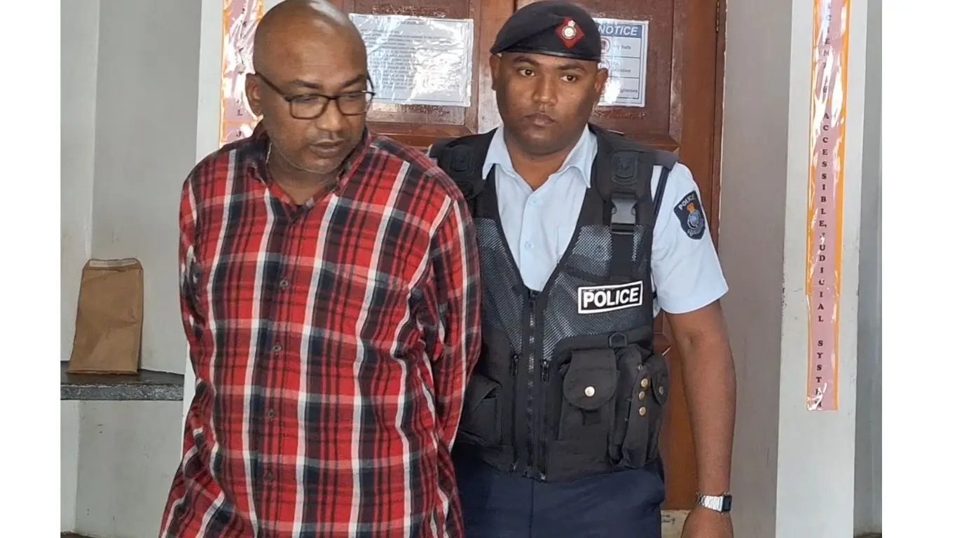 Accused Vishal Rohit Prasad is escorted by a police officer after appearing at the Nadi Magistrate Court on August 7, 2026. 