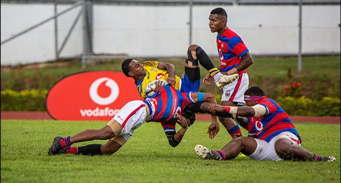 Gutsy Suva Grammar School Under-17 full-back Josefa Saratibau holds on to the ball despite copping a tackle against Marist Brothers High School in the Vodafone Super Deans Trophy final at Churchill Park, Lautoka, today. Photo:Leon Lord