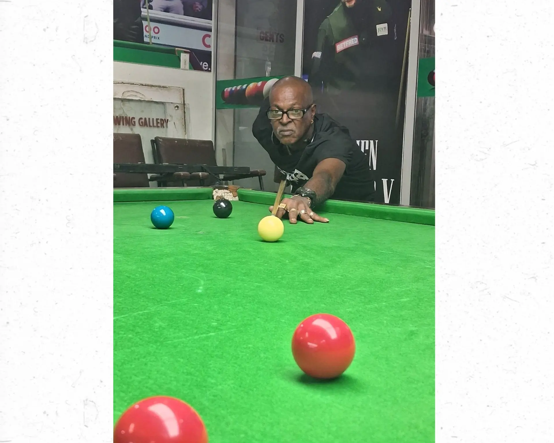 Albert Maharaj lines up a shot during a snooker match.