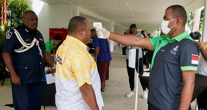 Acting Commissioner of Police Rusiate Tudravu (left), and Minister for Defence Inia Seruiratu (getting temperature checked), at the Fiji Police Force National Community Policing Symposium at the Pearl Resort in Pacific Harbour on January 28, 2021. Photo: Police Media Cell