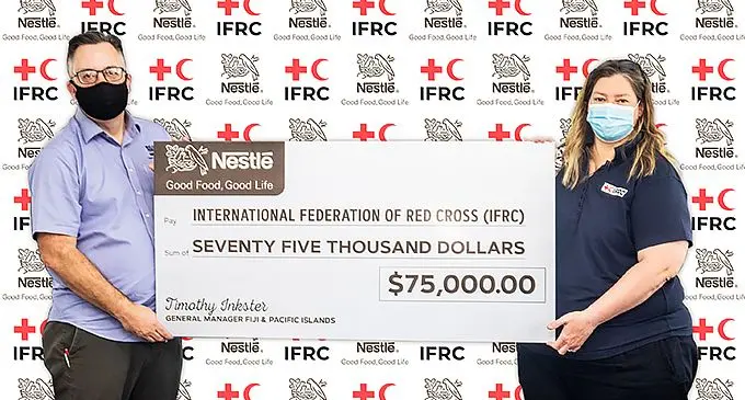 Nestle Fiji General Manager Tim Inkster hands over cheque to IFRC Pacific Head of Delegation Katie Greenwood. Photo: Nestle Fiji